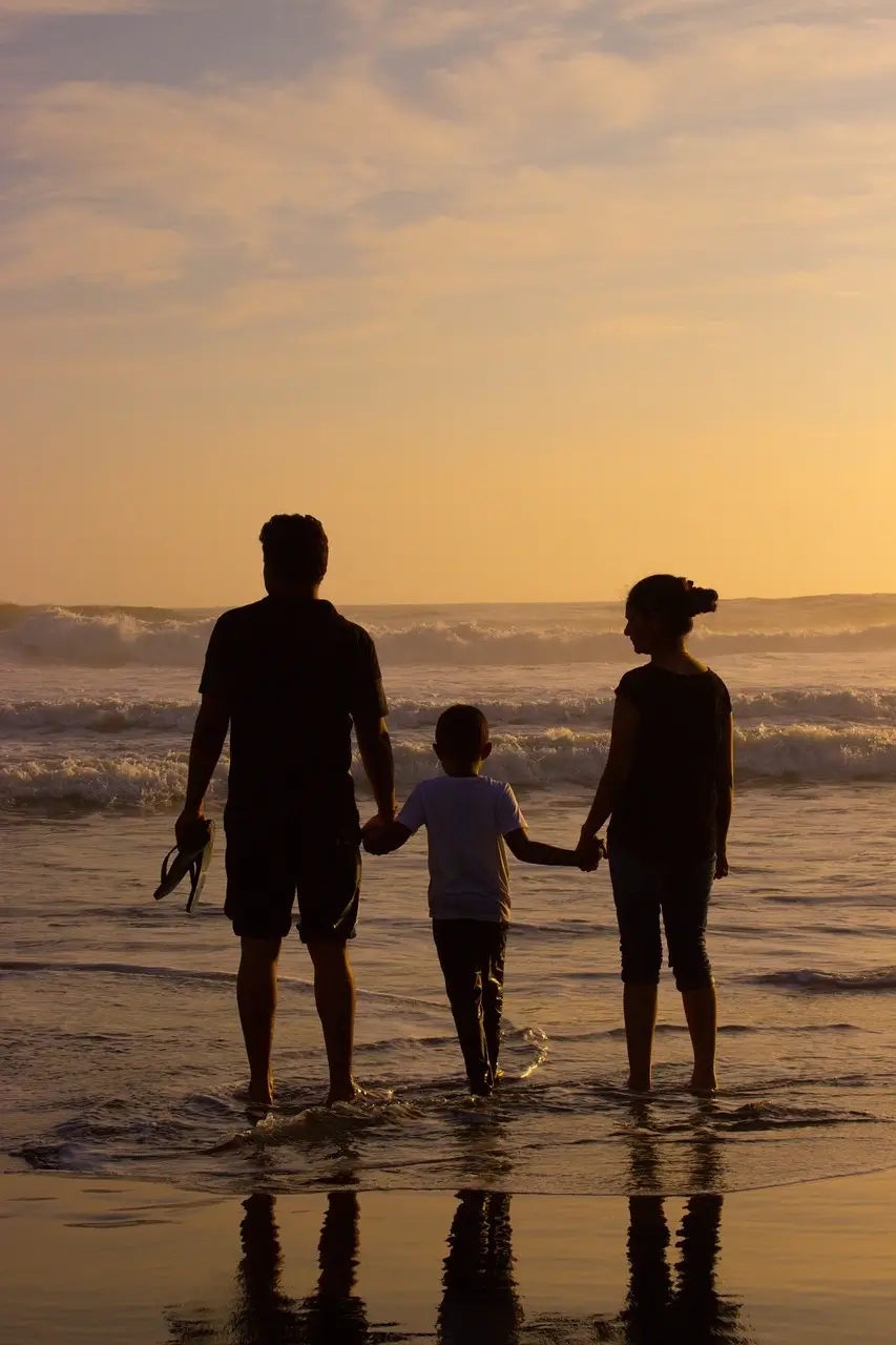 Une famille soudée de dos face à la mer